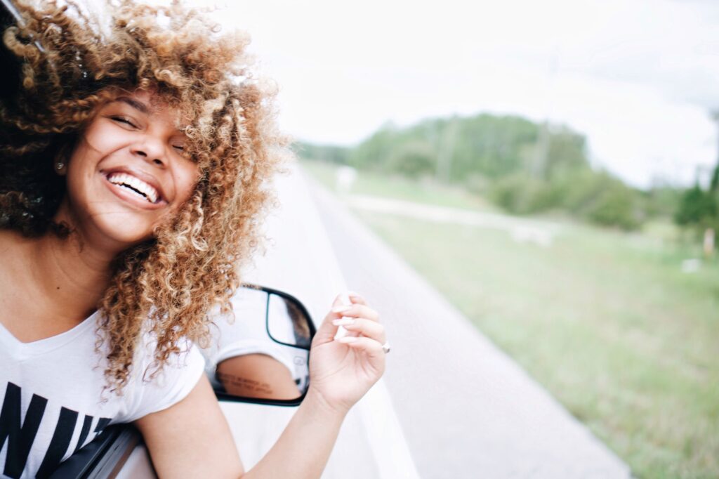 Happy woman smiling and feeling free on a road trip